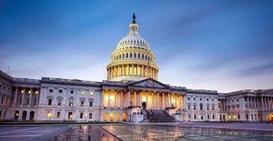 Le Capitole des États-Unis au crépuscule, avec un éclairage spectaculaire mettant en valeur son dôme emblématique et son architecture néoclassique dans un ciel dégagé.