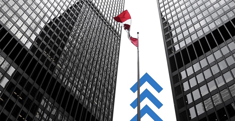Le drapeau canadien flotte devant un grand immeuble