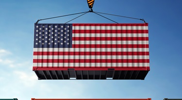 U.S. cargo container hangs against background of clouds in sky