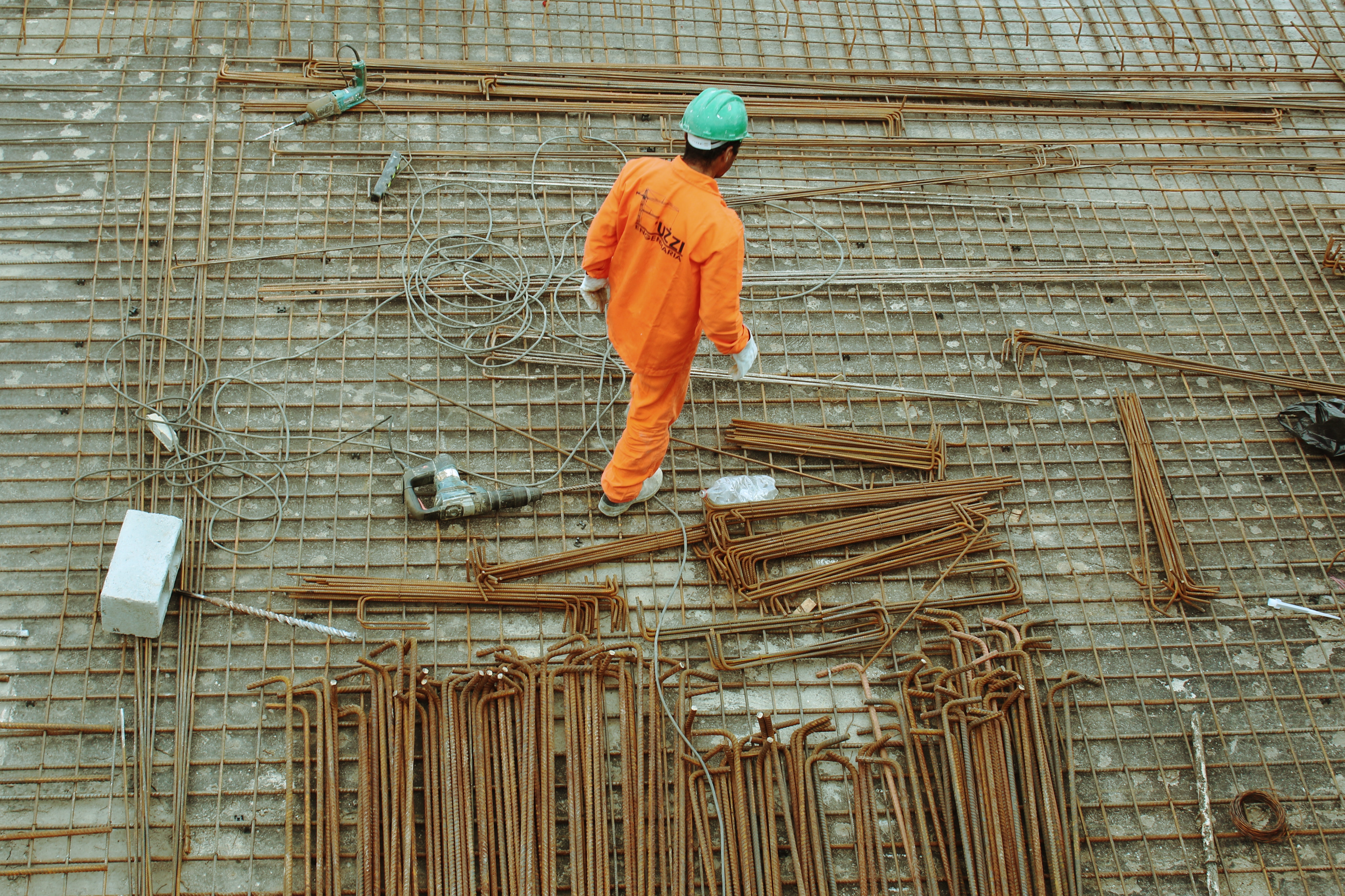 Ouvriers qui passent devant des tiges d’acier sur un chantier de construction.