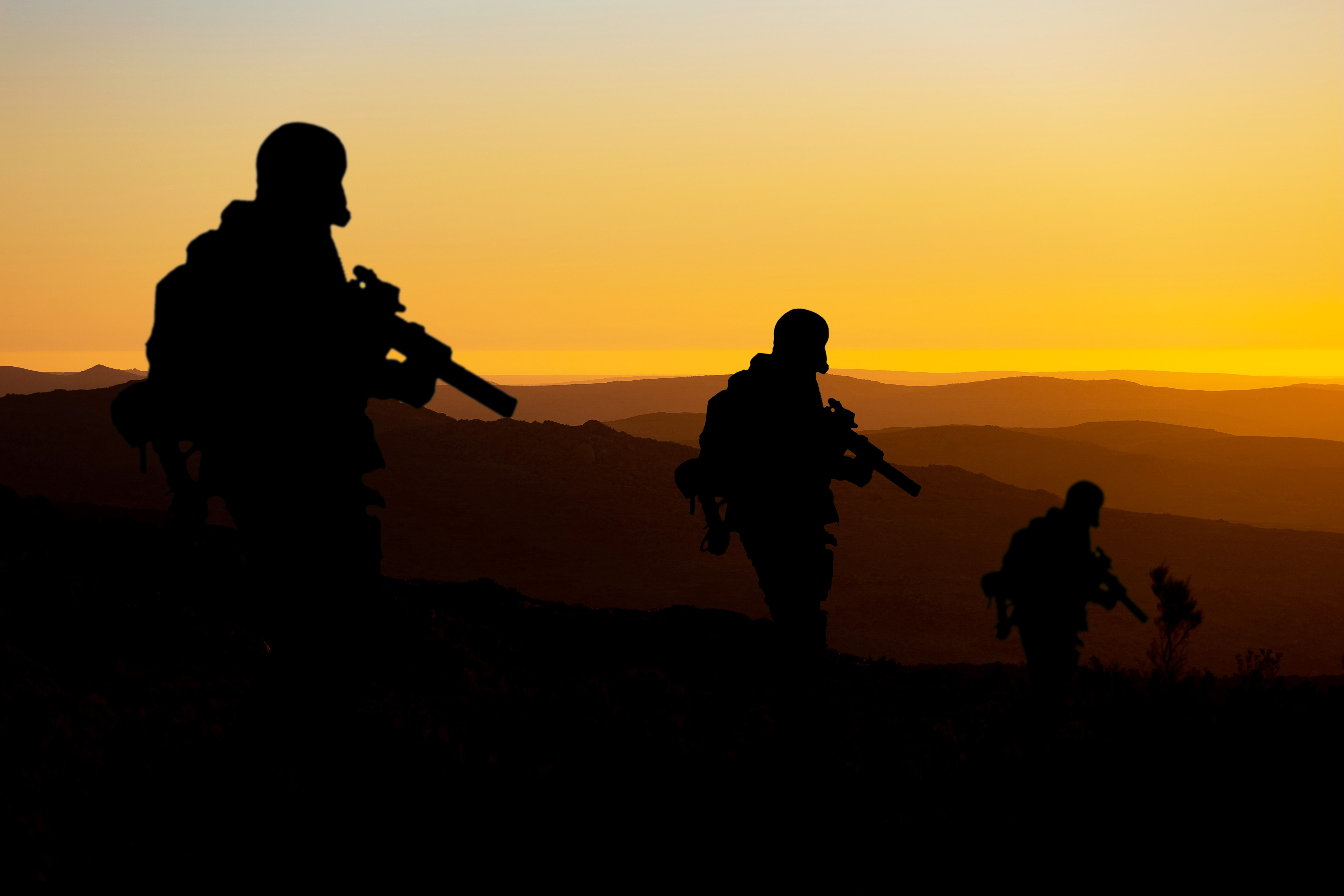 Silhouette of a soldiers at sunset symbolizing war and geopolitical tension.