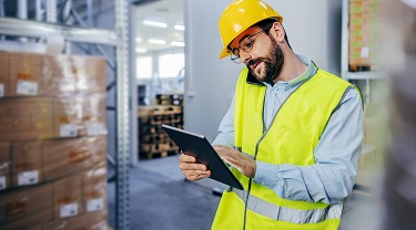 Un chef d’entrepôt vérifie son stock sur sa tablette.