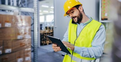 Un chef d’entrepôt vérifie son stock sur sa tablette.