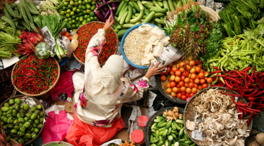 Femme de confession musulmane vendant des légumes frais au marché de Kota Bharu en Malaisie