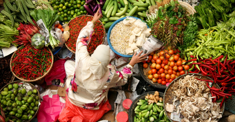 Femme de confession musulmane vendant des légumes frais au marché de Kota Bharu en Malaisie