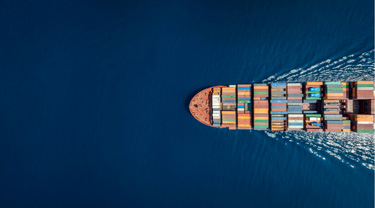 Aerial view of a container ship in blue ocean, representing global trade