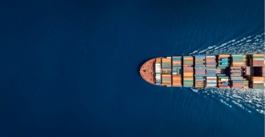 Aerial view of a container ship in blue ocean, representing global trade