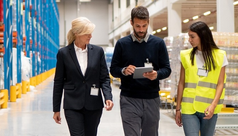 Warehouse employees discuss order fulfillment.