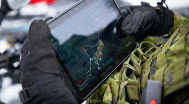 Militaire canadien utilisant une tablette lors d'un exercice militaire hivernal dans l'Arctique.