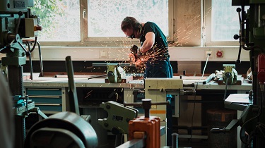 Male metalworker uses welding machine.