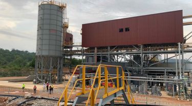 Exterior view of CEC’s integrated plant with workers in safety vests and helmets.