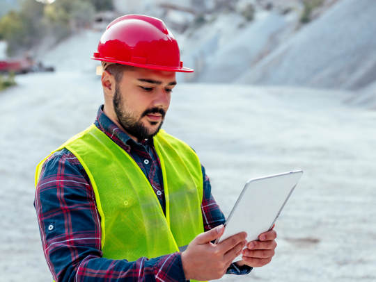 Mining engineer studying working documentation on tablet at the mining site