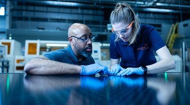 Two technicians at Silfab work on a solar panel.