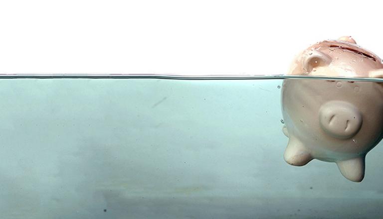 La tirelire qui flotte dans l'eau représente le besoin d’une analyse coût-avantage comme outil de gestion du risque de non-paiement par vos clients 