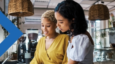 Two servers have a conversation in a coffee shop