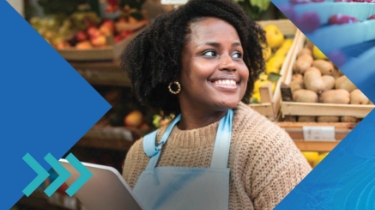 Employee in produce section of grocery store holding a smart tablet