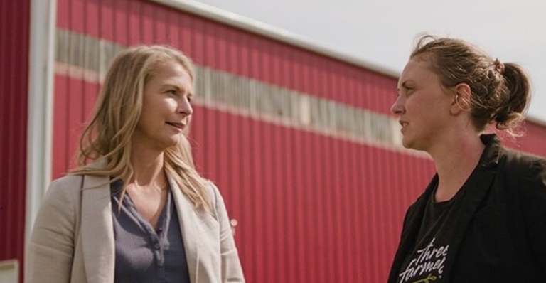 Deux agricultrices en conversation près d’un bâtiment agricole