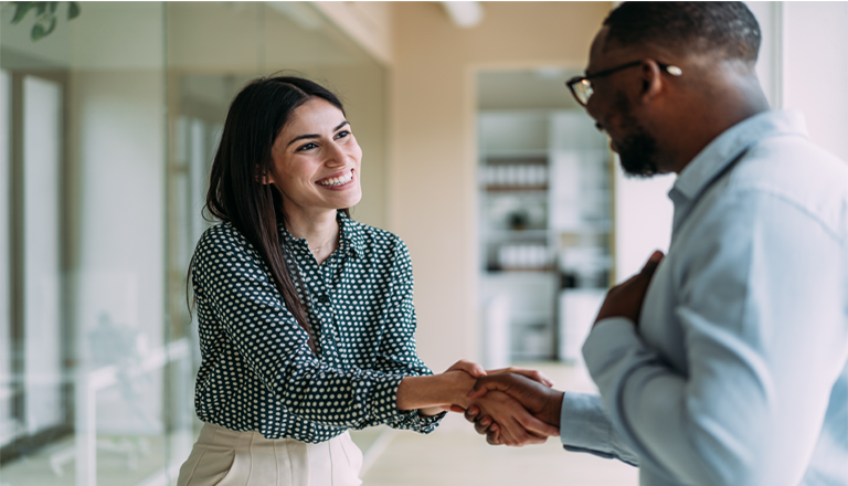 Business people shaking hands in an office, symbolizing buyer relationships.