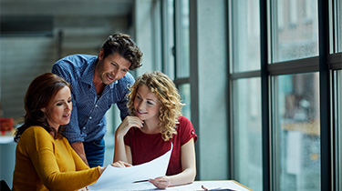 Le gérant d'entrepôt discute de la logistique d'exportation et de la gestion des stocks avec une équipe sur le plancher de l'entrepôt. 