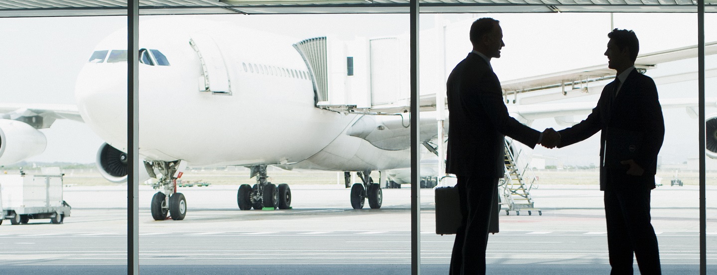 Businessmen shake hands after meeting at airport