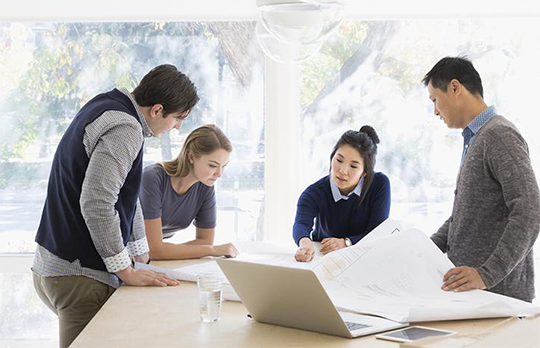 Four business colleagues around a table looking at a document