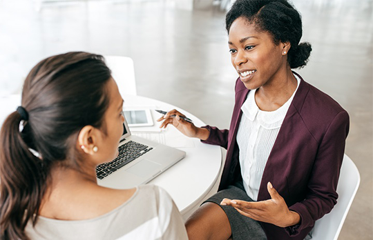 Two business colleagues talking sitting at a table