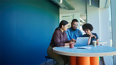 Three people discussing work at the office