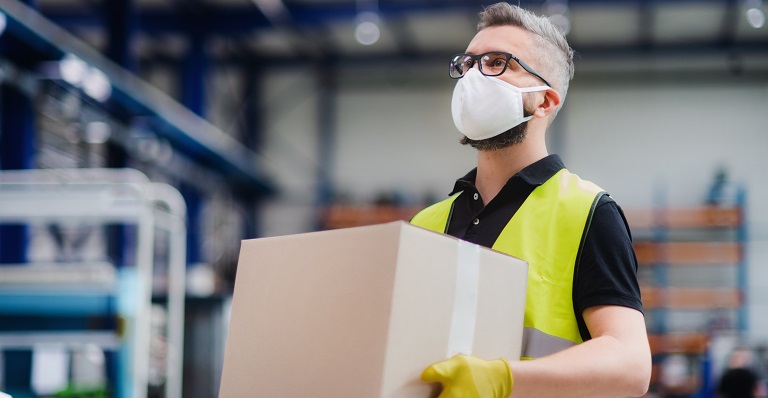 Male warehouse worker carries goods for shipping