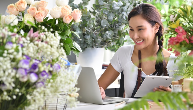 Flower shop owner ordering supplies on her laptop
