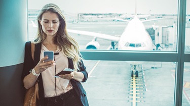 Female exporter looks at phone in airport