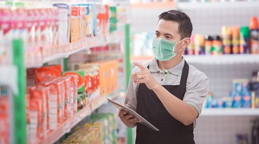 Asian grocery store clerk takes inventory of his stock.