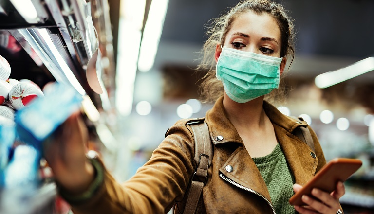 Femme portant un masque de protection à l’épicerie