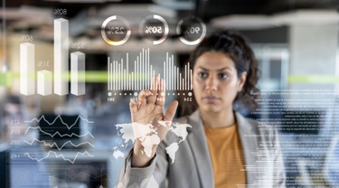 Latin American businesswoman look at the market data on an interactive screen.