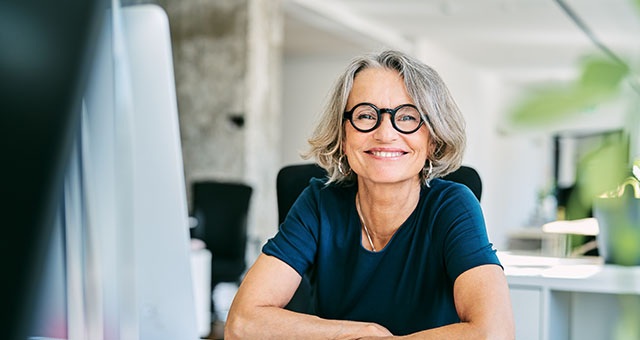 A happy mature businesswoman working in a business office.