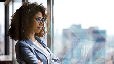 Young woman in business suit looking through office window