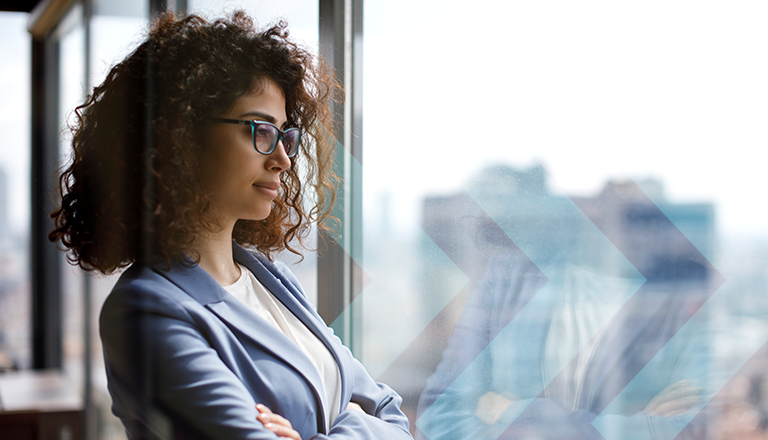 Young woman in business suit looking through office window