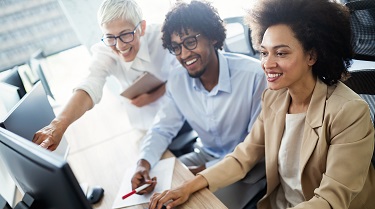 Three diverse business partners look at computer