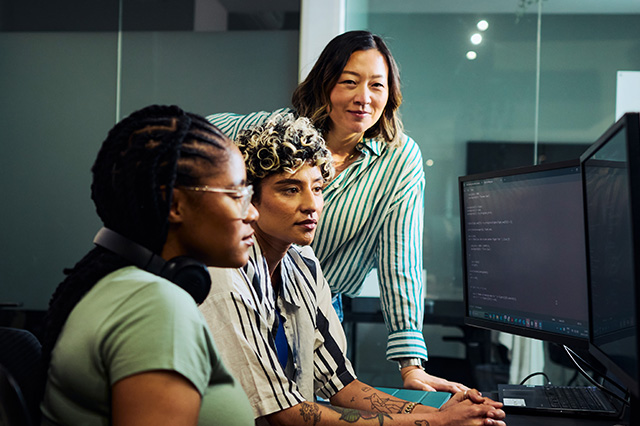 Team of software consultants collaborating while looking at a computer monitor