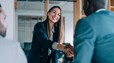 Female trade expert welcomes business owners into her office.