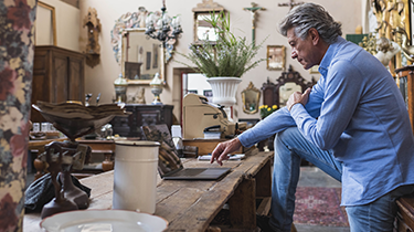 A person sitting on a table looking at a computer