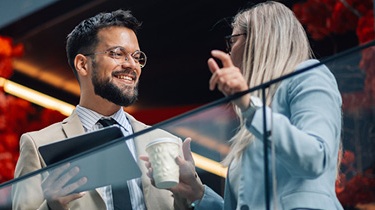 Colleagues discussing business financing for exporters on an office balcony.