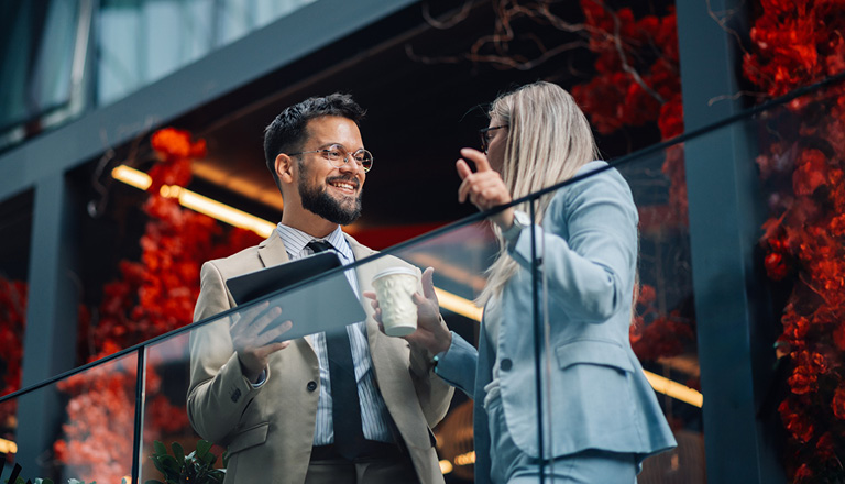 Colleagues discussing business financing for exporters on an office balcony.