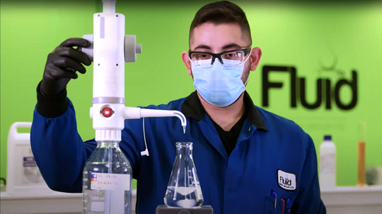 A man mixes ethanol ingredients to make hand sanitizer.