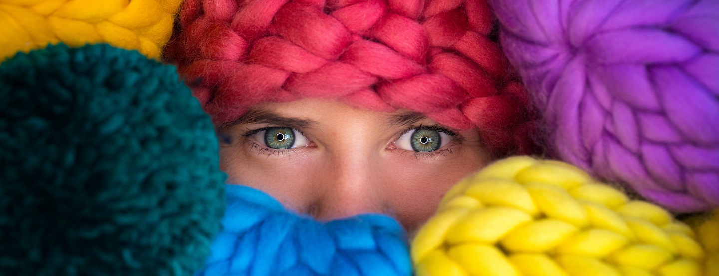 An entrepreneur peeks out from behind her colourful wool inventory.