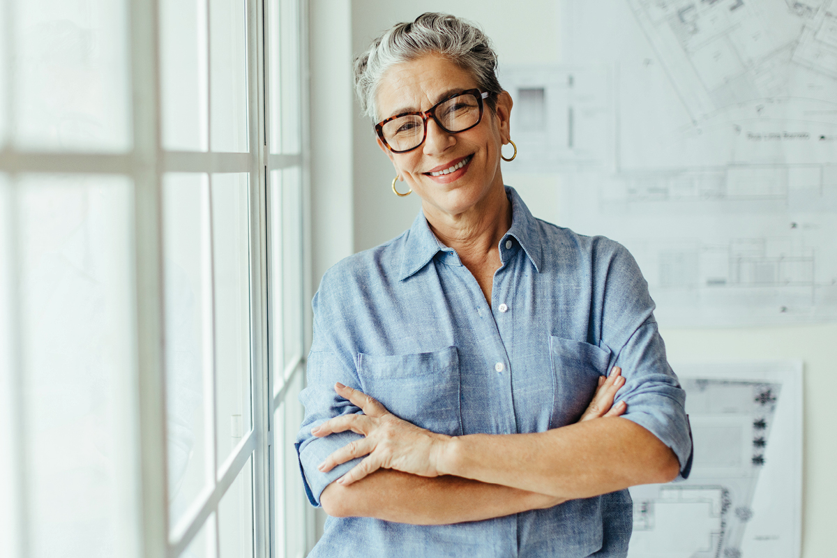 A mature and accomplished businesswoman, smiling directly at the camera.