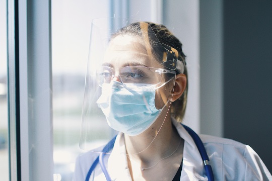 A woman wears the face shield developed by InkSmith.