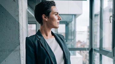 Image d'une belle femme d'affaires debout dans son bureau et regardant à travers la fenêtre.