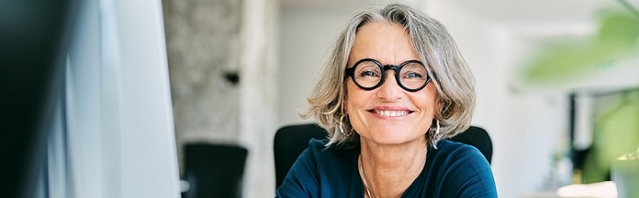 A happy mature businesswoman working in a business office.