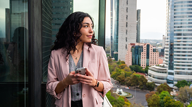 Canadian exporter researching international pricing strategies on her phone in Mexico City.