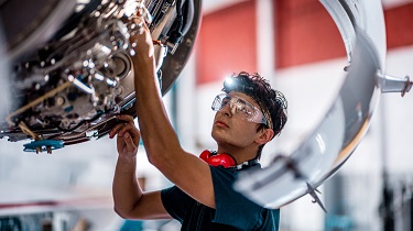 Aircraft mechanic checks engine.